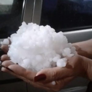 Moradora segura granizo que caiu neste sábado (31), em Colombo, na Região de Curitiba — Foto: Soraia Castilho/Reproduçã