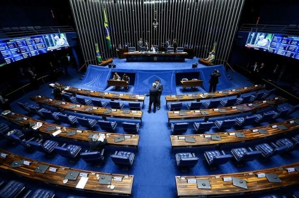 Em uma vitória para o presidente eleito Luiz Inácio Lula da Silva (PT), o Senado aprovou, no fim da noite de ontem, a “PEC da Transição”, que libera espaço no Orçamento de 2023 para as promessas de campanha do petista e abre caminho para destravar despesas deste ano bloqueadas pelo teto de gastos, inclusive do orçamento secreto.  Em troca de votos, contudo, o Senado ampliou “penduricalhos” à proposta inicial, que, segundo técnicos do Congresso, podem elevar o impacto da medida a mais de R$ 200 bilhões.  O texto passou por dois turnos de votação, além dos destaques. Um deles reduzia a validade da PEC para apenas um ano, mas foi rejeitado.  O texto da “PEC da Transição” aprovado vai além do impacto de R$ 168 bilhões — decorrentes do aumento do teto em R$ 145 bilhões e da autorização de usar até R$ 23 bilhões em investimentos em caso de excesso de arrecadação. Outros “puxadinhos” incluídos na proposta podem levar o impacto total da medida a R$ 205,1 bilhões.  Além disso, para aprovar a proposta, o PT abriu mão de manter apenas com o governo eleito o poder de indicar a destinação do espaço que a PEC abre em outros programas: pelo texto aprovado, deputados e senadores também decidirão quais programas e ministérios receberão mais recursos em 2023.  No segundo turno, foram 64 votos a favor e 13 contra — a maioria da base bolsonarista —, placar semelhante ao do primeiro turno, de 64 e 16. A proposta precisava de 49 dos 80 votos na Casa antes de seguir para a Câmara.  A equipe de Lula trabalha com o limite do dia 22 para fazer as alterações no Orçamento e garantir um Bolsa Família de R$ 600 em janeiro — sem isso, cairia a R$ 400.  Além de novas exceções às regras fiscais que já havia incluído no texto, antes da votação da PEC na Comissão de Constituição e Justiça (CCJ) na terça-feira, o relator, senador Alexandre Silveira (PSD-MG), apresentou na noite de ontem uma nova versão de seu relatório.  Esta amplia a autorização de gastos da PEC — embora algumas destas exceções não impactem diretamente as receitas da União, por serem decorrentes de doações, parcerias de entidades públicas ou mesmo recursos não sacados das contas do PIS/Pasep.  Mudança nos \'penduricalhos\'  Na votação, o senador Humberto Costa (PT-PE) afirmou que a PEC seria necessária mesmo se Lula não tivesse sido eleito:  — Qualquer que fosse o presidente da República eleito, pelas condições que nós temos hoje de predefinição do Orçamento da União para o ano de 2023, seria necessária uma PEC como esta ou outro instrumento que garantisse a folga fiscal necessária para que pudéssemos atender não somente os compromissos assumidos pelos candidatos, mas também para o cumprimento desses compromissos.  A maioria dos senadores que votou contra a PEC é da base governista. Cinco deles são do PL, partido de Bolsonaro: Flávio Bolsonaro (RJ), Carlos Viana (MG), Carlos Portinho (RJ), Romário (RJ) e Marcos Rogério (RO).  O parecer apresentado por Silveira no plenário trouxe duas mudanças nos “penduricalhos” da PEC. O relator retirou do teto de gastos as despesas pagas com recursos próprios, doações e convênios de todas as instituições científicas, tecnológicas e de inovação (ICTs).  Antes, essa mudança beneficiava apenas a Fundação Oswaldo Cruz (Fiocruz) e teria impacto de R$ 7,5 bilhões. Com a ampliação, a medida também valerá para a Embrapa, com projeção de impacto de R$ 3,5 bilhões.  Além disso, o relator ampliou para dezembro de 2023 o prazo de execução de recursos dos fundos estaduais e municipais de saúde e assistência social que receberam transferências da União no período da pandemia.  Essa medida atendeu a uma demanda do Conselho Nacional de Secretários de Saúde (Conass), feita ao presidente do Senado, Rodrigo Pacheco (PSD-MG). O conselho estima haver entre R$ 1,5 bilhão e R$ 2 bilhões nesses fundos da Covid-19 apenas nos estados, e que a ampliação do prazo permitirá o uso desses recursos em um momento de alta no número de casos da doença.  Na terça-feira, antes da aprovação da PEC na CCJ, Silveira havia incluído pontos que prevêem a retirada permanente do teto de gastos das despesas da área de meio ambiente pagas com doações nacionais e internacionais, despesas da Fiocruz, despesas de educação pagas com receitas próprias, doações ou de convênios celebrados com demais entes e recursos do extinto PIS/Pasep que não tenham sido sacados e estejam parados há mais de 20 anos.  Atualmente, segundo a Caixa, há R$ 24,6 bilhões em contas “esquecidas” do PIS/Pasep. Esses valores poderão ser usados integralmente em 2023 ou ao logo dos anos, para investimentos do governo federal. Além disso, técnicos estimam que o impacto da retirada das despesas da Fiocruz do teto seja de R$ 7,5 bilhões no ano que vem, valor que se soma aos R$ 5 bilhões das despesas de educação que sairiam do teto desta rubrica. No caso das despesas com receitas próprias de universidades federais, o montante fica em torno de R$ 1,5 bilhão.  A PEC ainda tira do teto despesas feitas via empréstimos de órgãos multilaterais, como o Banco Mundial e o Banco Interamericano de Desenvolvimento (BID). Atualmente, o governo federal tem poucos empréstimos nessa situação, já que o mecanismo é mais usado por estados e municípios.  No caso do PIS/Pasep, os valores, segundo o texto da PEC, “serão tidos por abandonados” e “apropriados pelo Tesouro Nacional para realização de despesas de investimento” fora do teto de gastos. O valor entrará como receita primária e sairá como gasto, de maneira a ter um saldo fiscalmente neutro no fim.